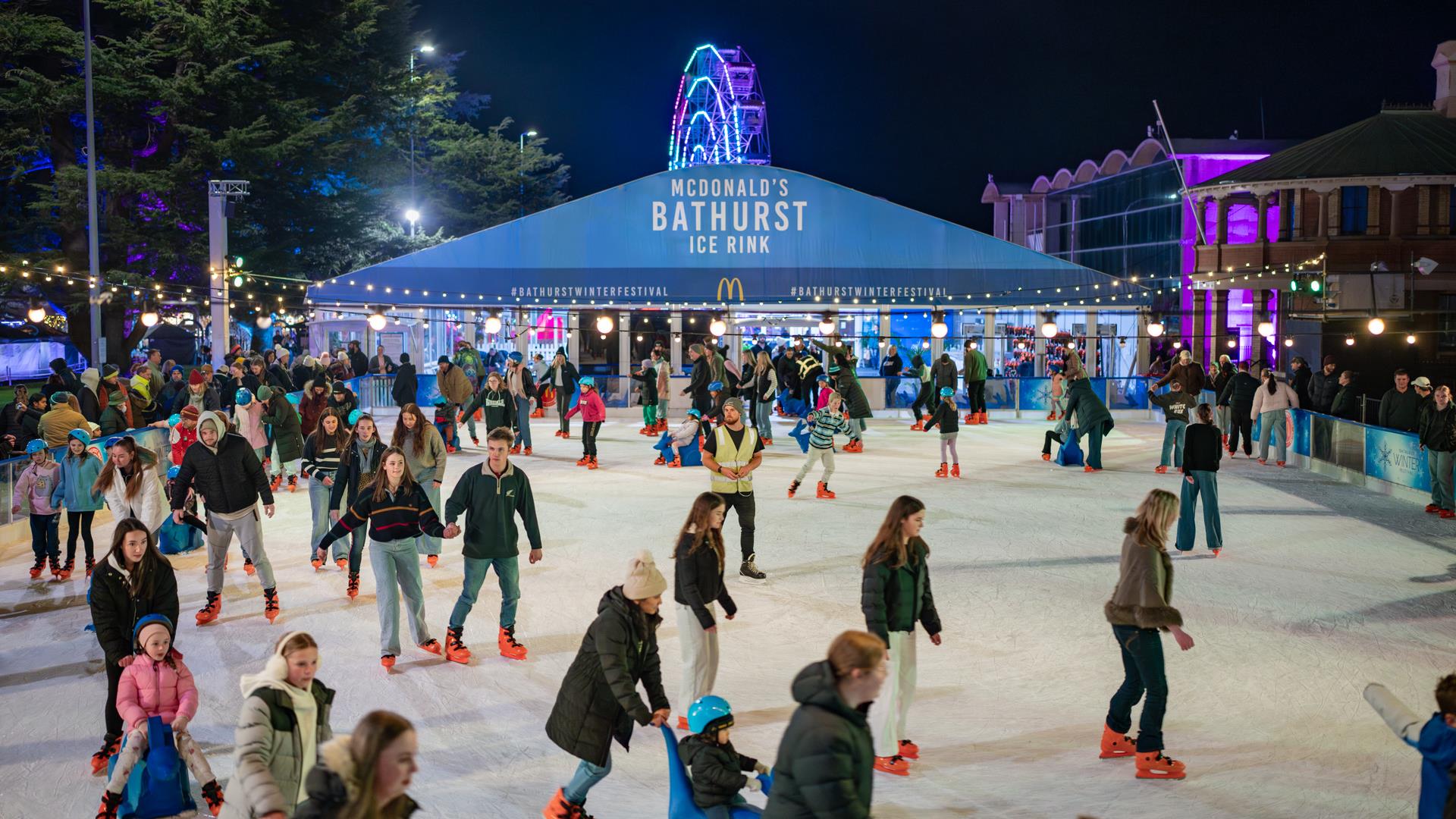 Crowds enjoying ice skating at night.