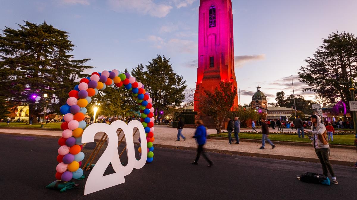 Giant 200 numbers in a balloon arch with illuminated Carillon in the background.